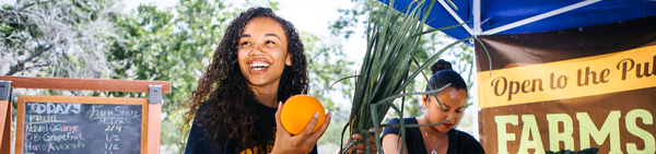 Girl eating orange at a fair